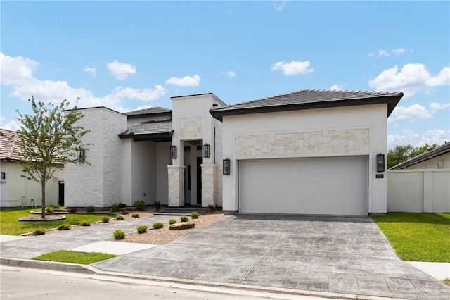 contemporary home featuring a garage, driveway, stucco siding, and fence