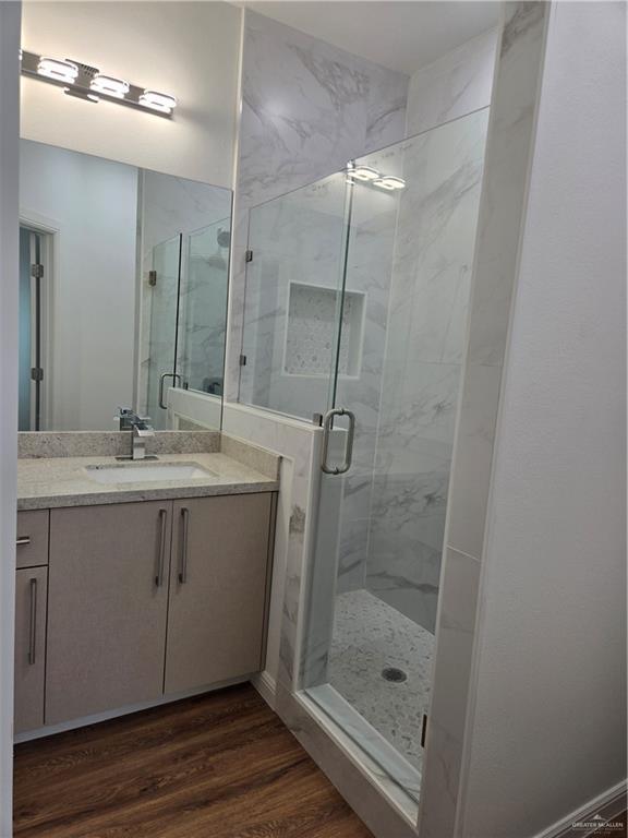 901 E Yuma Ave Unit 206, Mcallen, TX 78503 - full bath featuring a marble finish shower, wood finished floors, and vanity