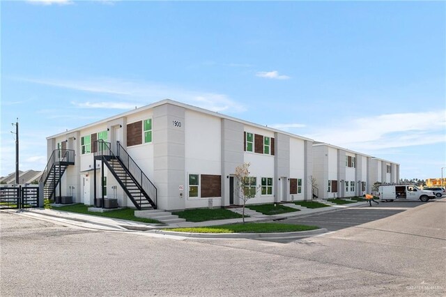 901 E Yuma Ave Unit 206, Mcallen, TX 78503 - view of property featuring uncovered parking, stairway, and central AC unit