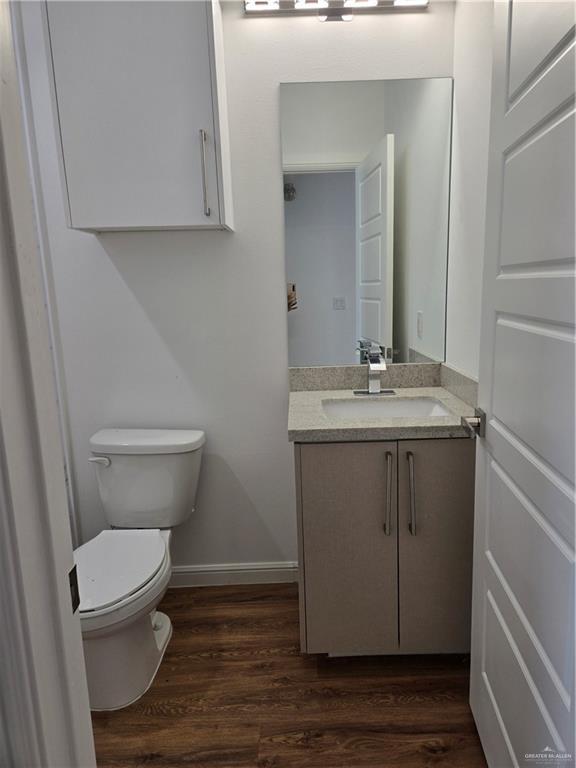 901 E Yuma Ave Unit 206, Mcallen, TX 78503 - half bath with toilet, wood finished floors, baseboards, and vanity
