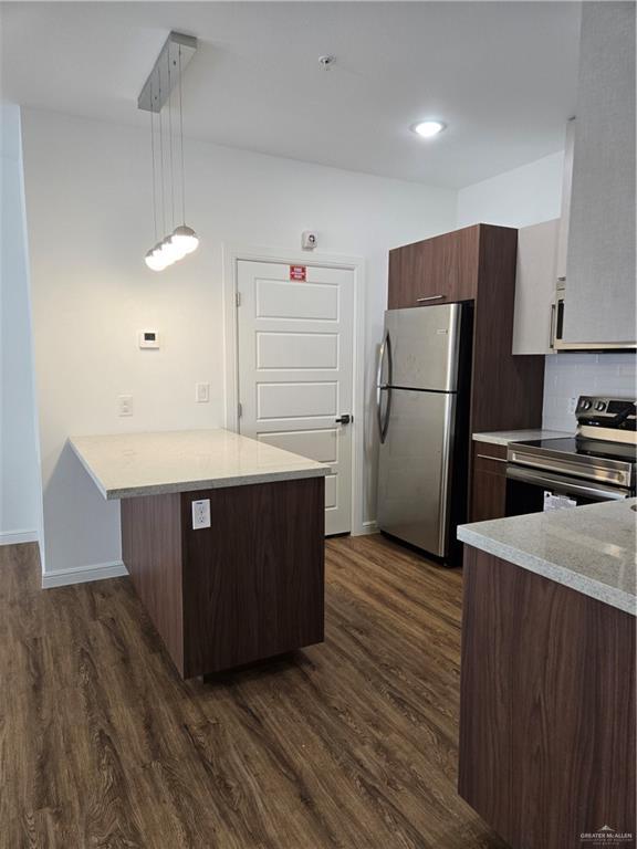 901 E Yuma Ave Unit 206, Mcallen, TX 78503 - kitchen with light countertops, stainless steel appliances, backsplash, dark wood-style floors, and a peninsula