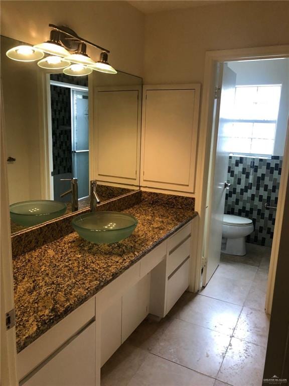 bathroom featuring tile patterned flooring, vanity, tile walls, and toilet