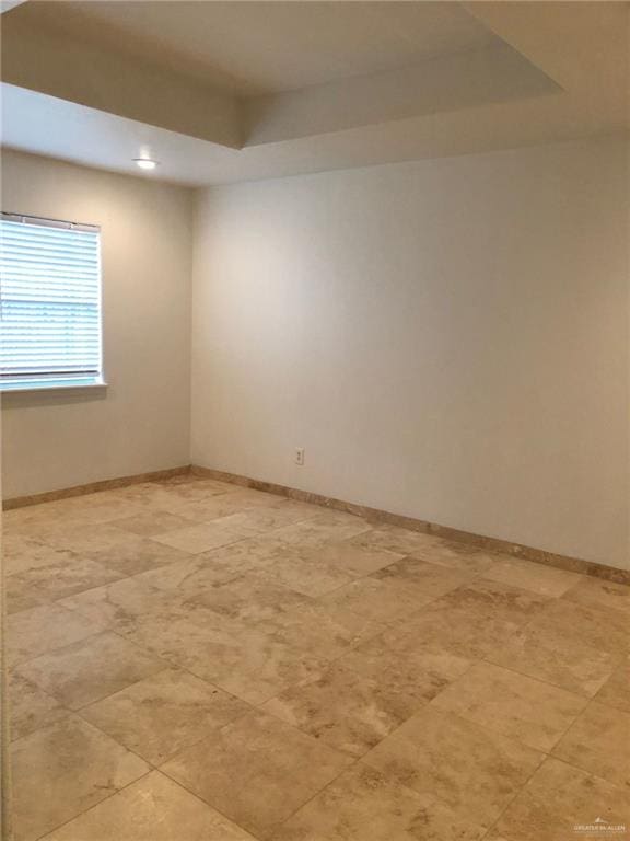 unfurnished room with a raised ceiling