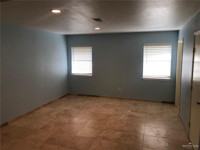 spare room with a textured ceiling and a wealth of natural light