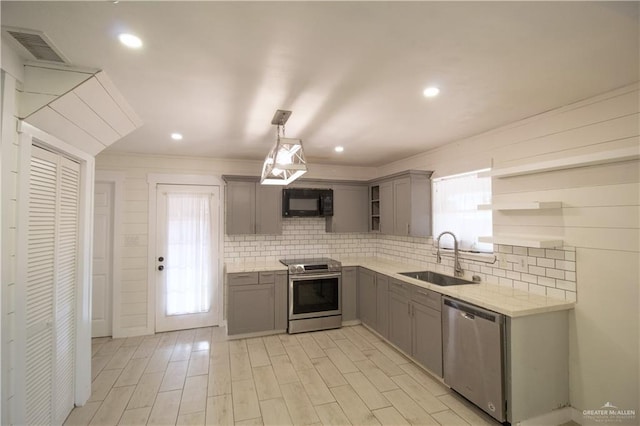 kitchen with stainless steel appliances, open shelves, visible vents, a sink, and gray cabinetry