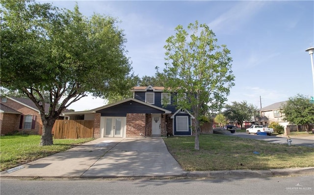 traditional-style house with fence, driveway, french doors, and a front yard