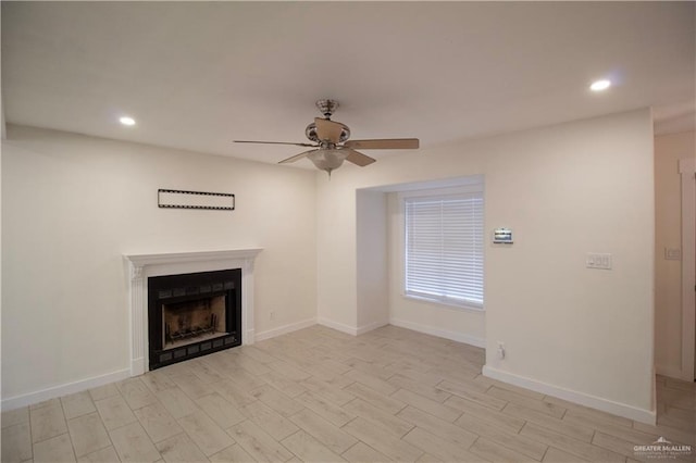 unfurnished living room with ceiling fan, recessed lighting, a fireplace, and light wood-type flooring
