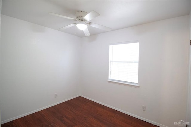 spare room featuring baseboards, dark wood-type flooring, and ceiling fan
