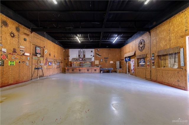 garage featuring a workshop area and wood walls