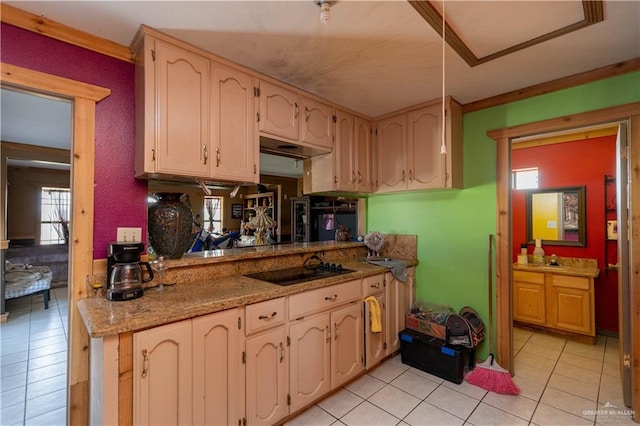 kitchen featuring black electric cooktop, light stone counters, sink, and light tile patterned floors