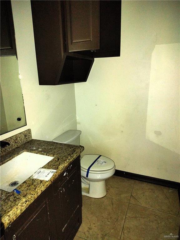 bathroom featuring tile patterned flooring, vanity, and toilet