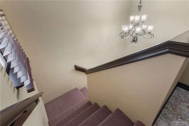 staircase with a chandelier