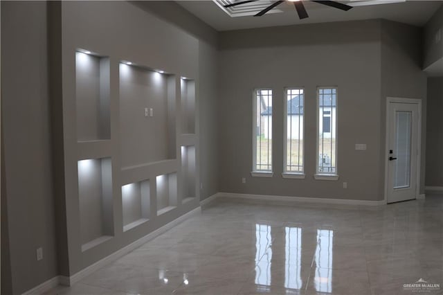 unfurnished room with ceiling fan and a towering ceiling