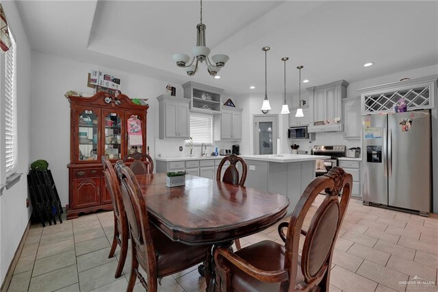 tiled dining space featuring sink and an inviting chandelier