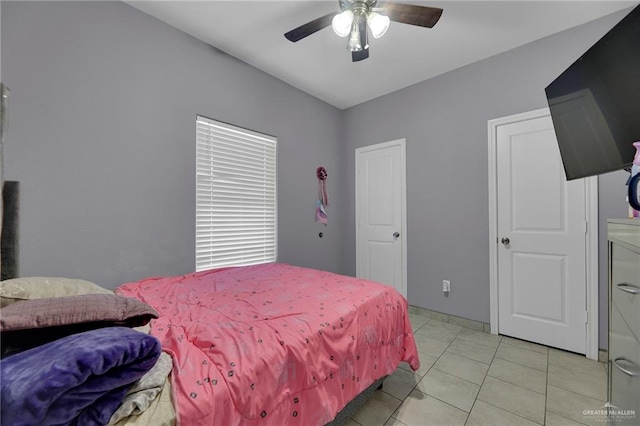 tiled bedroom featuring ceiling fan