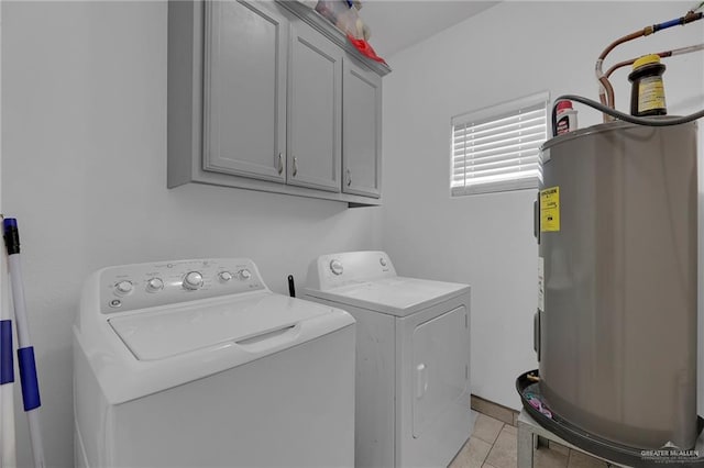 washroom with washer and dryer, light tile patterned flooring, cabinets, and water heater