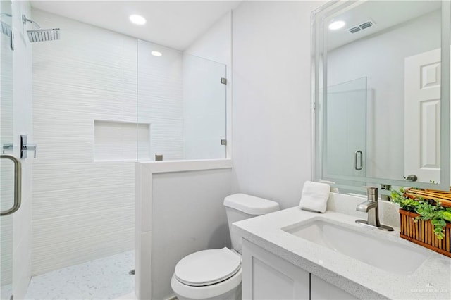 bathroom featuring vanity, toilet, and a shower with shower door