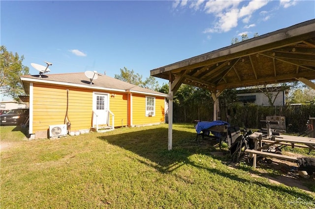 rear view of property featuring ac unit, a gazebo, and a lawn