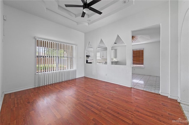 4217 W Ithaca Ave, Mcallen, TX 78501 - unfurnished living room with ceiling fan, wood finished floors, a raised ceiling, and baseboards