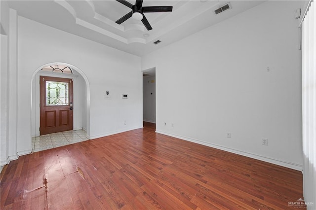 4217 W Ithaca Ave, Mcallen, TX 78501 - spare room with a tray ceiling, arched walkways, ceiling fan, wood finished floors, and baseboards
