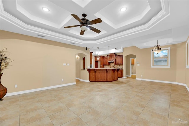 unfurnished living room featuring ceiling fan with notable chandelier, a raised ceiling, and ornamental molding