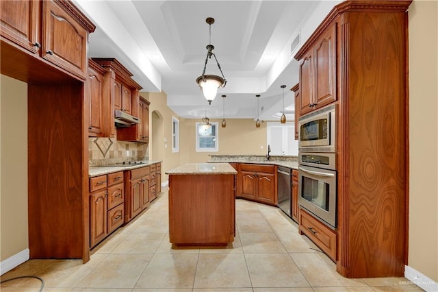 3218 Lerma Dr, Edinburg, TX 78539 - kitchen with appliances with stainless steel finishes, a peninsula, a kitchen island, light stone counters, and backsplash