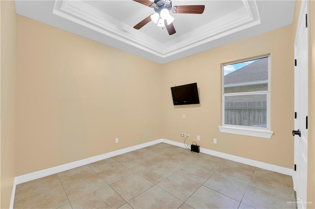 tiled spare room with a tray ceiling, ceiling fan, and crown molding