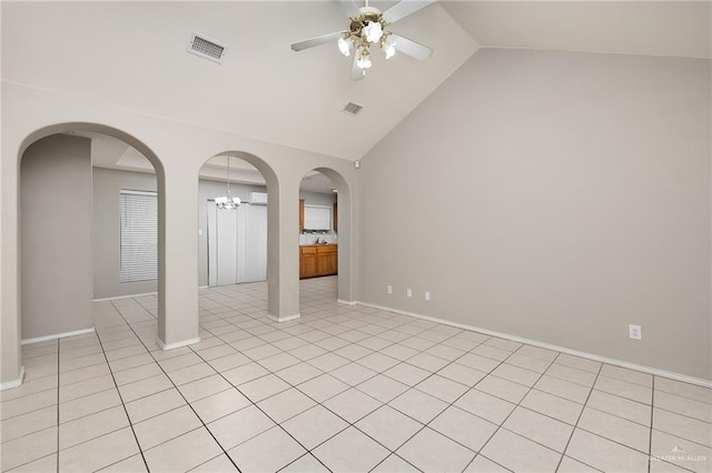 unfurnished room featuring ceiling fan with notable chandelier, light tile patterned flooring, and vaulted ceiling