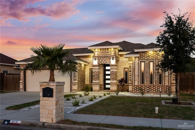 view of front of house with a garage, brick siding, concrete driveway, and fence