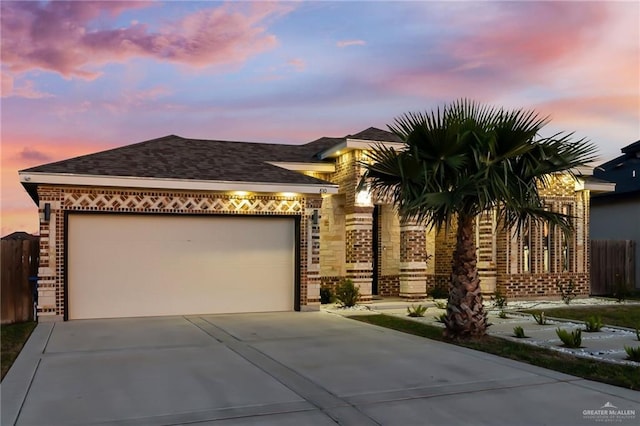 view of front of property with brick siding, fence, concrete driveway, roof with shingles, and an attached garage