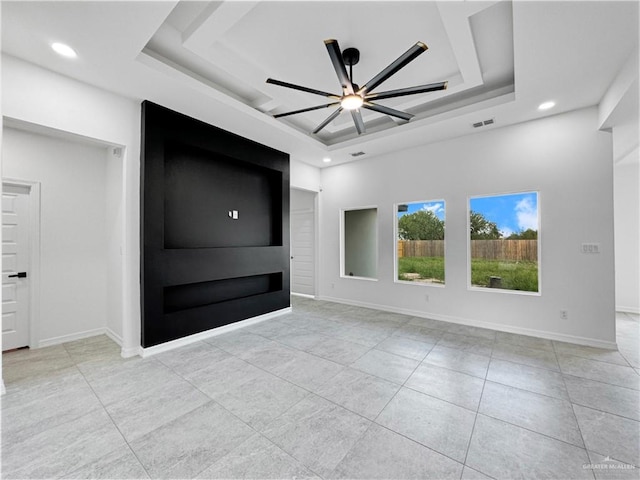 empty room featuring ceiling fan and a tray ceiling