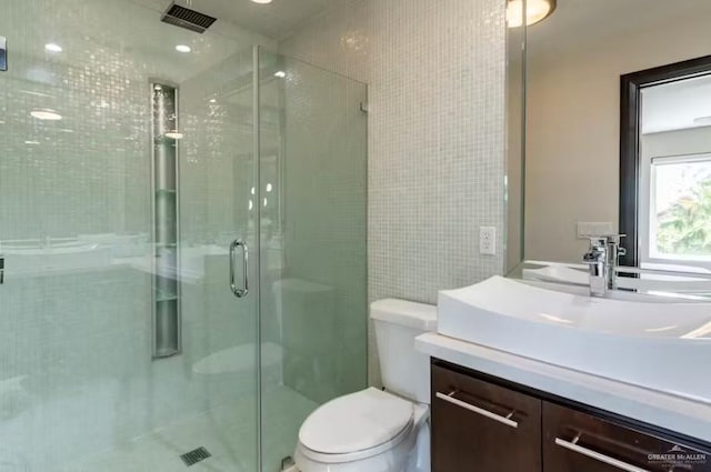 full bathroom featuring toilet, a shower stall, visible vents, and vanity