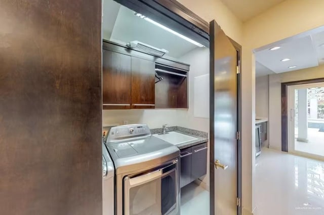 kitchen featuring light countertops, washer / clothes dryer, modern cabinets, and a sink