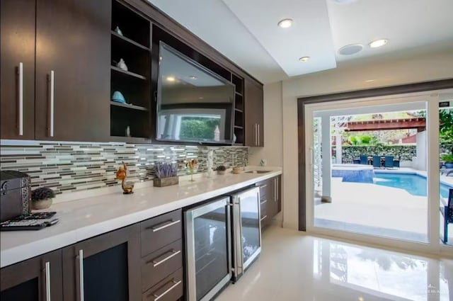 bar with wine cooler, backsplash, and a wealth of natural light