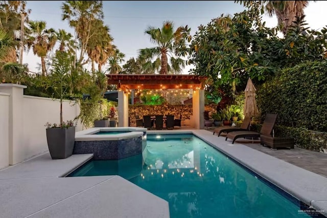 view of swimming pool with a patio area, a fenced backyard, a pool with connected hot tub, and a pergola