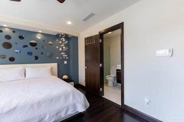 bedroom with dark wood-style floors, recessed lighting, visible vents, ensuite bath, and baseboards