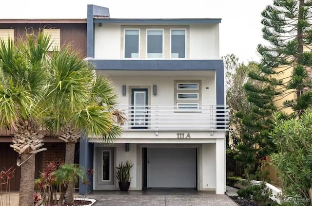 view of front facade with a balcony, a garage, decorative driveway, and stucco siding