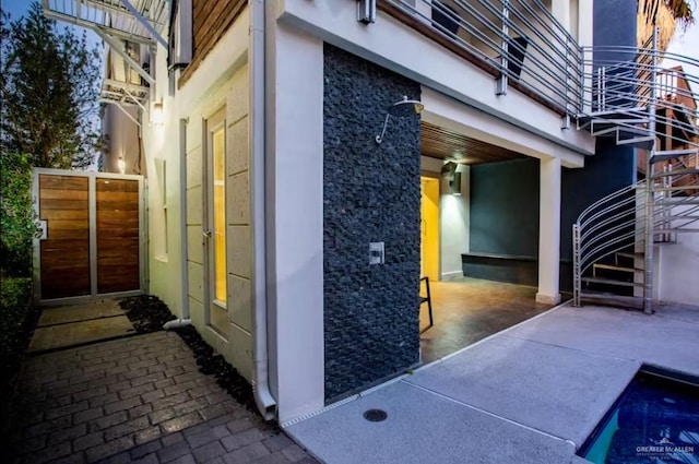 view of side of property featuring stairs and a patio area