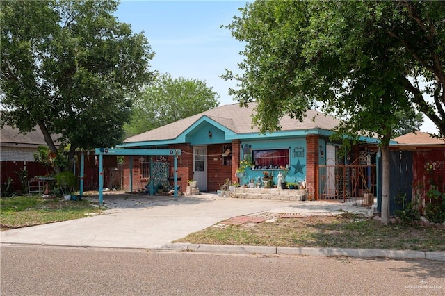ranch-style house with fence, an attached carport, driveway, and brick siding