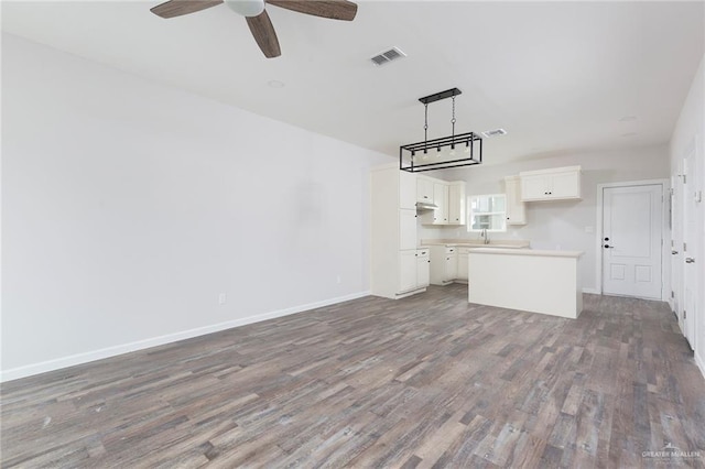 unfurnished living room with sink, dark hardwood / wood-style floors, and ceiling fan