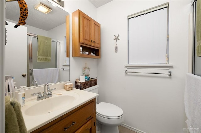 bathroom featuring vanity, walk in shower, and toilet