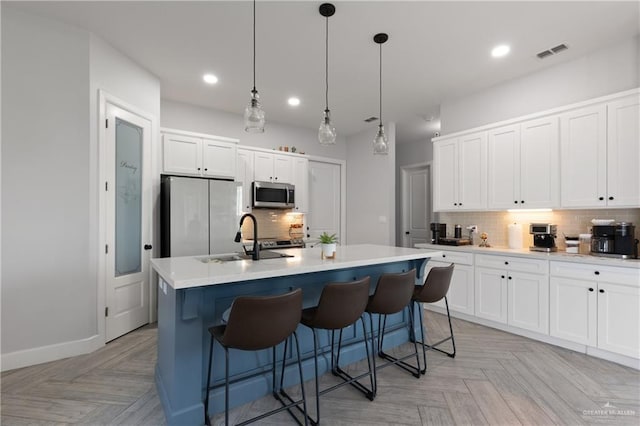 3702 Bea Ave, Harlingen, TX 78552 - kitchen with a sink, a center island with sink, backsplash, appliances with stainless steel finishes, and visible vents