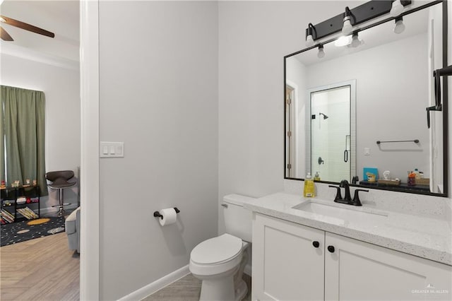 3702 Bea Ave, Harlingen, TX 78552 - bathroom with toilet, a stall shower, a ceiling fan, wood finished floors, and vanity
