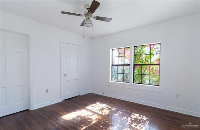 unfurnished bedroom featuring ceiling fan and dark wood-type flooring