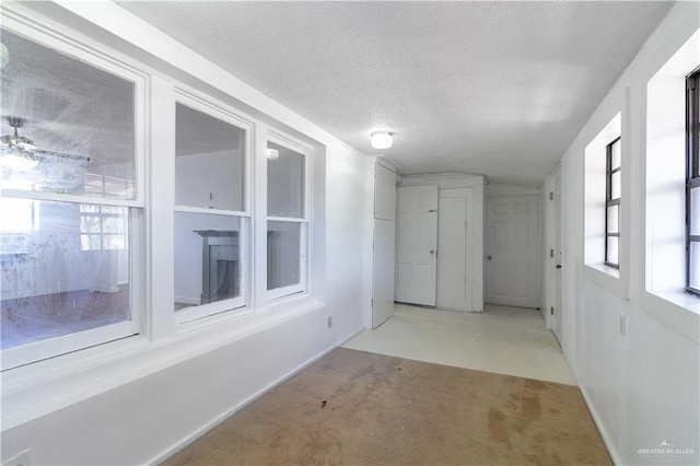 hall featuring light carpet and a textured ceiling