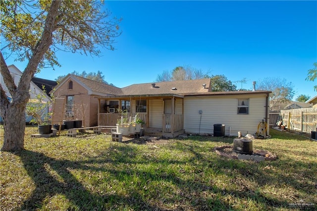 rear view of property featuring a lawn and central AC unit