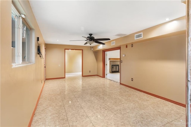 2408 River Oaks Ln, Edinburg, TX 78539 - unfurnished room featuring ceiling fan, baseboards, light tile patterned floors, and a glass covered fireplace