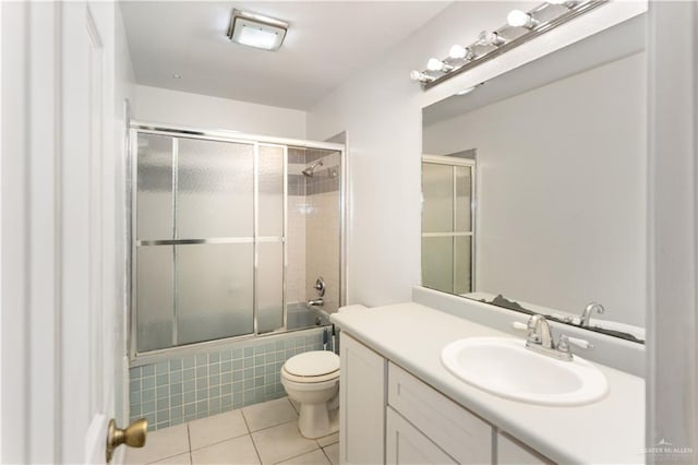 2408 River Oaks Ln, Edinburg, TX 78539 - bathroom with tile patterned floors, toilet, vanity, and bath / shower combo with glass door