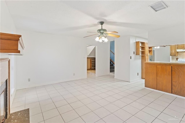 2408 River Oaks Ln, Edinburg, TX 78539 - unfurnished living room featuring a ceiling fan, stairs, and a fireplace