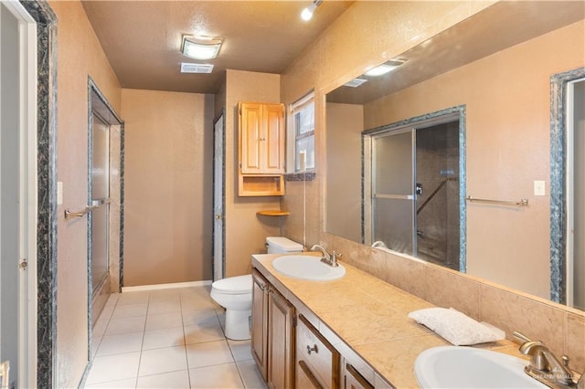 2408 River Oaks Ln, Edinburg, TX 78539 - bathroom with tile patterned floors, toilet, double vanity, and an enclosed shower